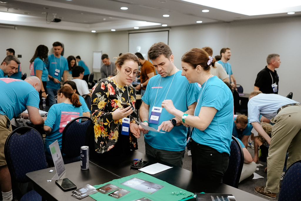 Equipes analisam informações e tomam decisões estratégicas em conjunto durante uma dinâmica presencial do jogo corporativo Falkenauge Sobrevivência.